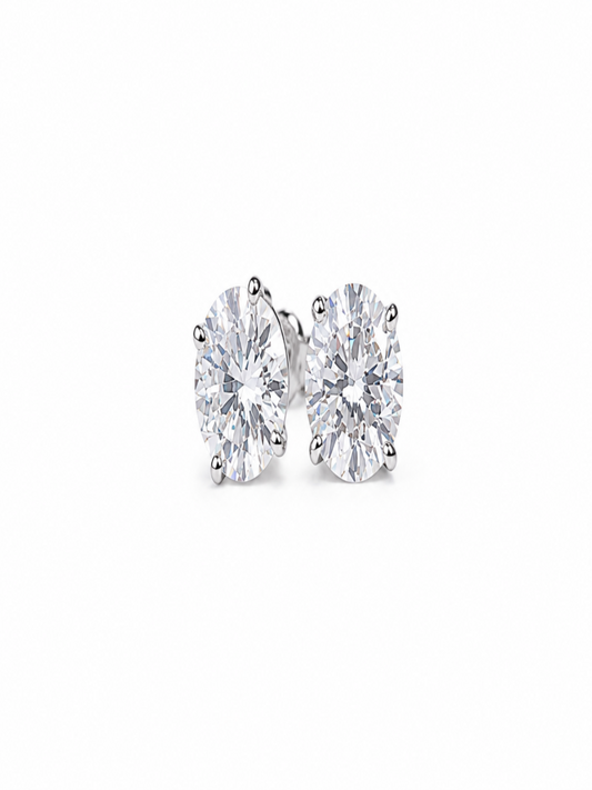 A pair of round-cut diamond stud earrings in a silver-toned setting, photographed on a clean white background.