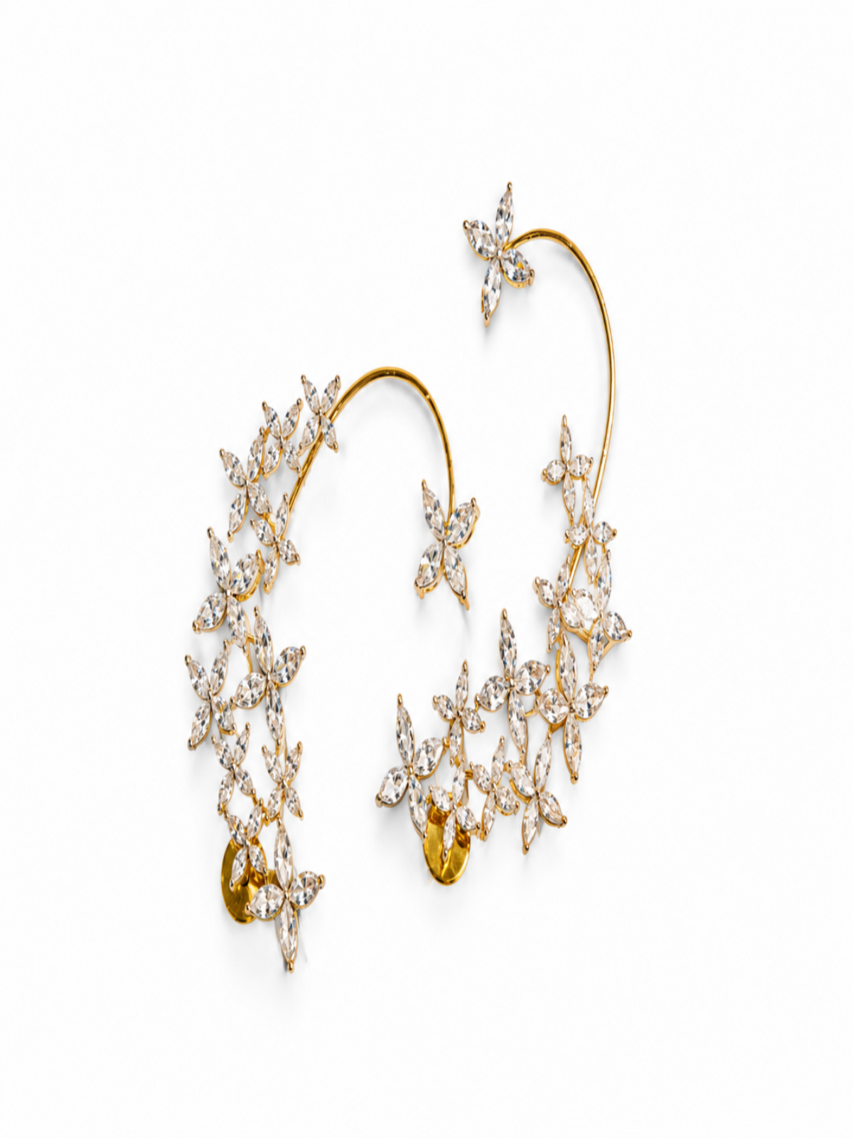 A pair of gold ear cuffs decorated with numerous clear marquise-cut gemstones arranged in starburst and floral clusters, set against a plain white background.