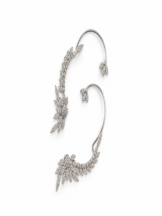 A pair of silver-toned ear cuffs adorned with pavé-set clear crystals in leaf and floral motifs, displayed on a clean white background.