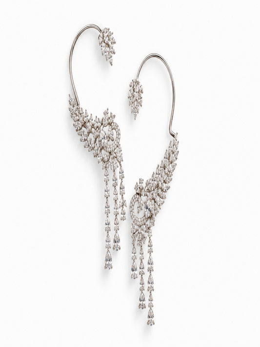 A pair of dramatic silver-toned hoop earrings adorned with intricate clusters of clear stones and long dangling chain drops, shown on a clean white background.