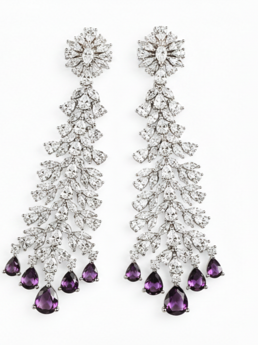 A pair of long chandelier drop earrings with clear faceted stones in a silver-toned setting, each ending in five black teardrop-shaped stones, shown on a plain white background.